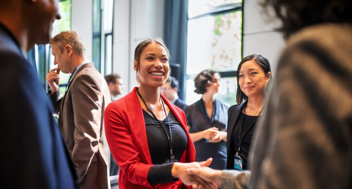 Businesswomen handshaking in auditorium corridor